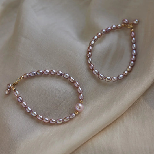 Two pearl bracelets on a beige fabric background